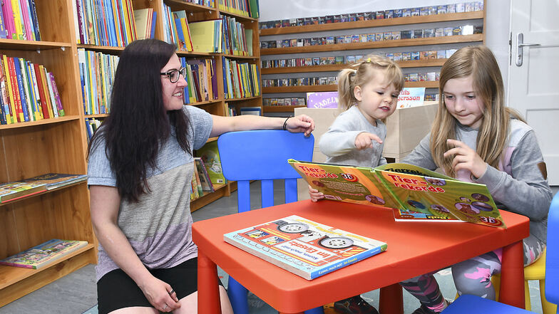 Isabel Graf sowie Pia und Lina im Zimmer mit der Kinderliteratur der Gemeindebibliothek Rietschen.