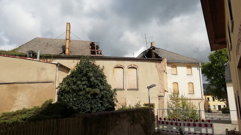 Beim rückwärtigen Blick auf die Gebäude sind die Schäden am Dach sichtbar.