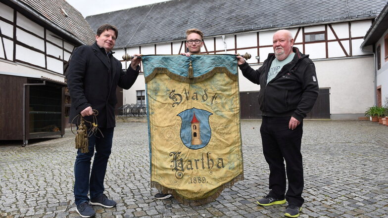 Fritz Schröder (mitte) und Stephan Mathys (rechts) übergaben die historische Fahne an Harthas Bürgermeister Ronald Kunze.