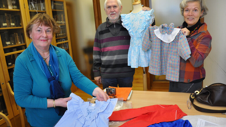 Alice Peterich (links) und ihr Mann Dieter Peterich besuchten 2016 das Prignitz-Museum in Havelberg, wo Kinderkleidung „Made in Havelland“ zu den Exponaten gehört. Die Museologin Sabine Ball (rechts) führte durch die Ausstellung.