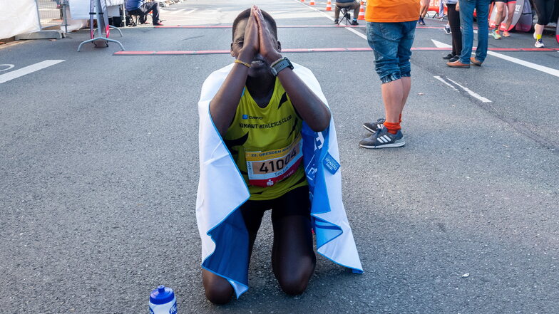 Mit göttlichem Beistand. Die Kenianerin Teclah Chebet unterbietet beim Dresden-Marathon den 19 Jahre alten Streckenrekord und weiß, bei wem sie sich erst mal bedanken möchte. Mit der Siegprämie könnte sie sich in der Heimat ein Haus kaufen.