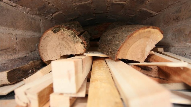 Unterm Ofen bunkert das gespendete Holz, baumastigecht oder tischlereigerecht geschnitten.