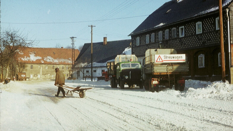 Ende der 1960er Jahre in Kottmarsdorf: Die Besatzung eines Winterdienstfahrzeuges macht in „Stadt Bautzen“ an der S148 Pause. In aller Ruhe quert ein Anwohner mit Schubkarre die Fahrbahn, die Verkehrsdichte war bescheiden.
