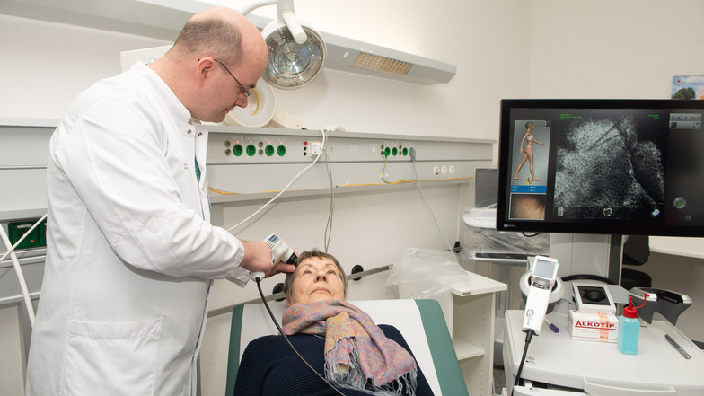Oberarzt Jörg Laske untersucht eine Patientin, die an ihrer Stirn einen Fleck entdeckt hatte. Mit dem Laser-Mikroskop kann Laske sofort feststellen, ob es sich bei der Veränderung um Hautkrebs handelt.