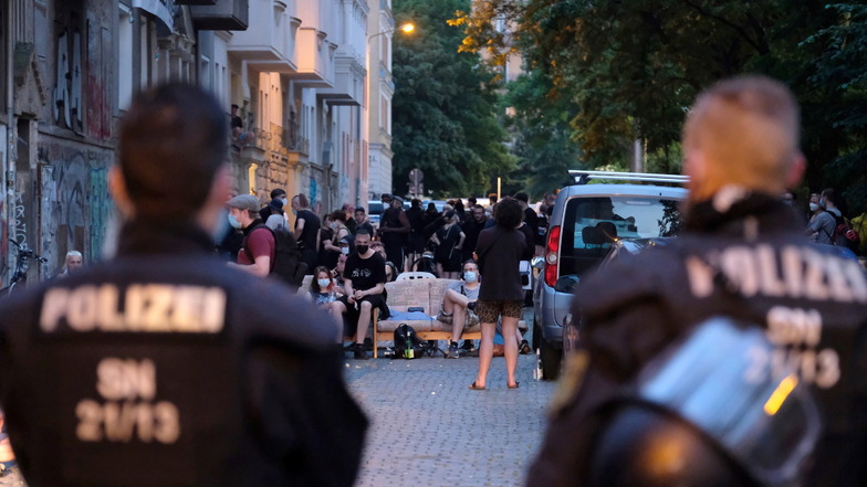 Polizisten stehen an einer Straße im Leipziger Osten vor einem Haus, das von Aktivisten besetzt wurde.