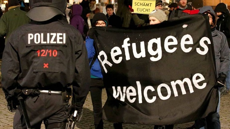 Die Gegendemonstranten heißen Flüchtlinge willkommen.