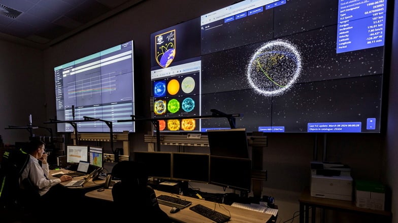Auf großen Bildschirmen werden im Weltraumlagezentrum der Bundeswehr in Uedem Daten zum Wiedereintritt des ausrangierten Batteriepakets der ISS in die Erdatmospäre angezeigt,
