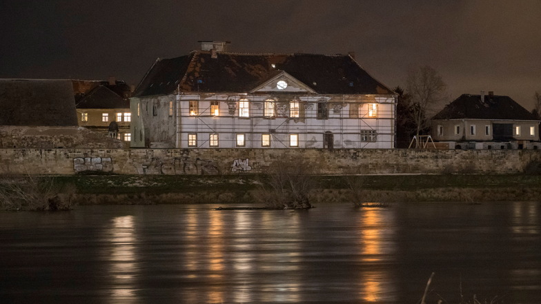 Seit einiger Zeithain ist das stark restaurierungsbedürftige Schloss Promnitz abends beleuchtet.