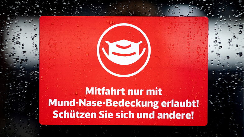 Schild der Deutschen Bahn: Mitfahrt nur mit Mund-Nase-Bedeckung erlaubt! Eine Mehrheit der Deutschen ist immer noch für die Maske in Bussen und Bahnen. Im Landkreis Meißen stagniert die Corona-Inzidenz.