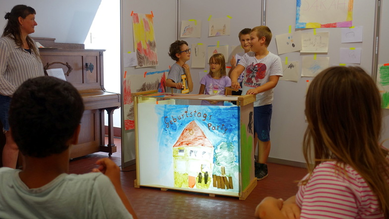 Die Kinder erzählen die Geschichte vom Riesenstiefel, der Geburtstag feiert. Die Bilder haben sie in den vergangenen Tagen selbst gestaltet.