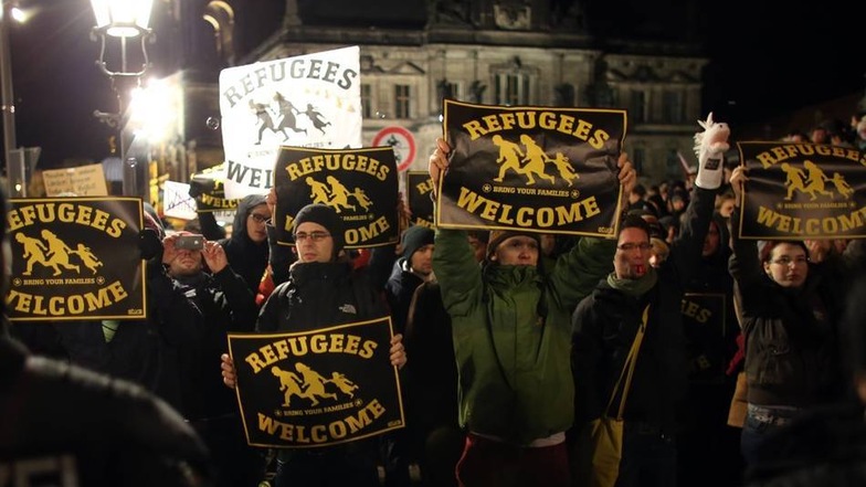 "Refugees welcome" (Flüchtlinge willkommen) steht auf Plakaten, die Teilnehmer der Gegen-Kundgebung von "Bündnis Nazifrei" auf dem Schlossplatz tragen. Sie wenden sich damit klar gegen das Hauptanliegen von Pegida.