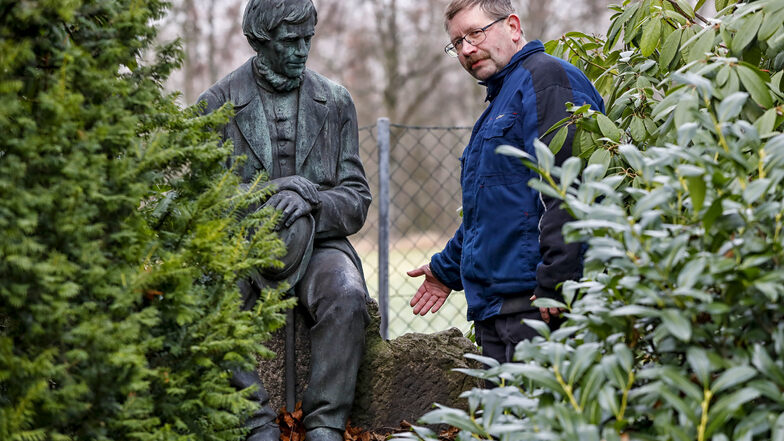Friedhofsverwalter Michael Dießner zeigt die Stelle, an der das Denkmal aus Bronze stand. Es handelt sich um einen Rucksack, der zur Leineweber-Figur gehörte.