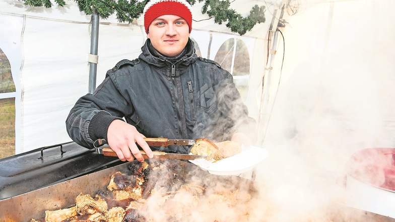 Paul Terpe vom Zabeltitzer Jugendclub bietet Dampfschwein mit Sauerkraut und Brot feil.