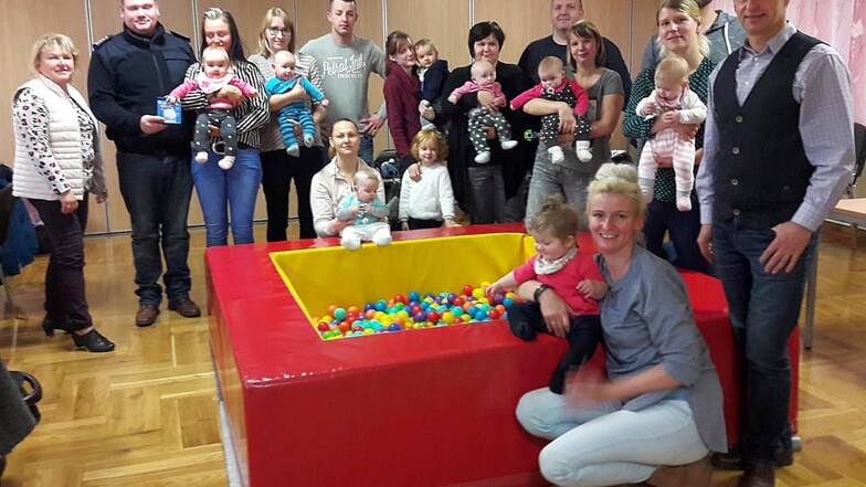 Der Wülknitzer Bürgermeister Hannes Clauß (r.) übergab Eltern von Neugeborenen aus seiner Gemeinde am Montag das Baby-Begrüßungsgeld der Kommune. 
