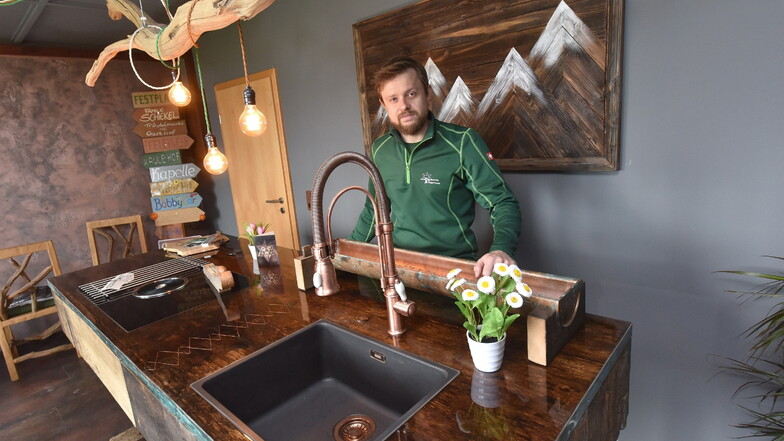 Der Meister und sein Vorzeigestück: Steven Kraftschenko mit dem Küchenblock aus altem Holz und modernen Elementen.