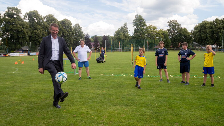 Roland Wöller ist als Innenminister auch für den Sport im Freistaat zuständig und nutzt den Termin in Rothenburg, um sich im Beisein der Nachwuchskicker selbst am Ball zu versuchen.