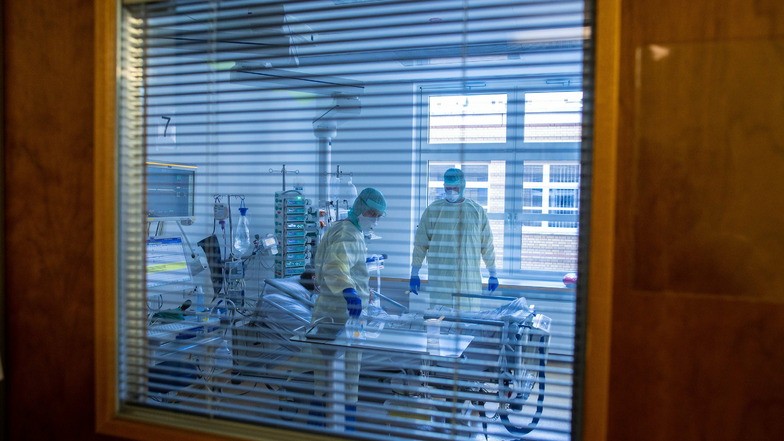 Mediziner und Pfleger versorgen einen an Covid-19 erkrankten Patienten auf der Intensivstation des Universitätsklinikums Greifswald. Ob der Patient je wieder richtig gesund wird, ist unklar.