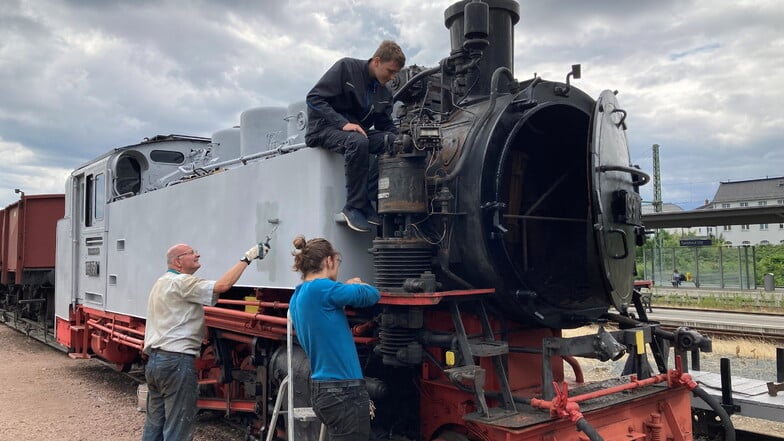 Schon weite Teile der Lokomotive 99 791 hat die neue Farbgebung. Am Dienstag waren Peter Reichler (l.), Robert Gränitz (auf der Lok) und Lukas Kuntzsch im Arbeitseinsatz.