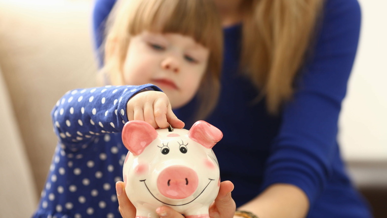 Rein ins Schwein: Einige Eltern wollen einen Teil vom erhöhten Kindergeld sparen.