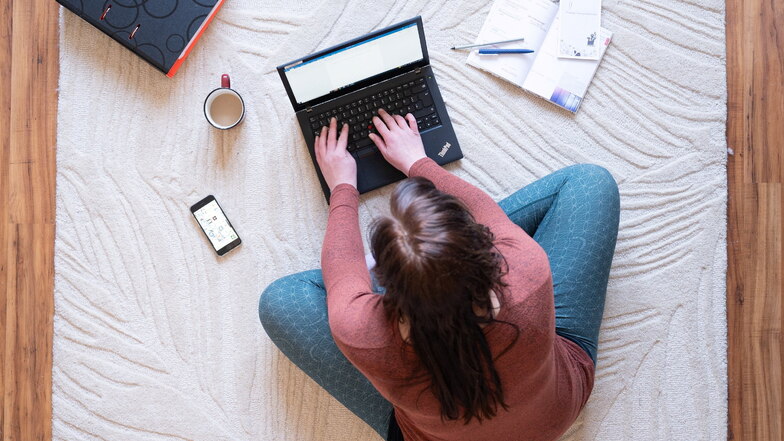 Eine junge Frau arbeitet im Homeoffice am Laptop. Unternehmen stehen Studien zufolge vor neuen Herausforderungen, etwa bei der Mitarbeiterbindung.