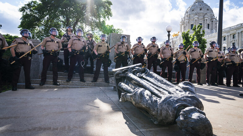 Polizisten stehen vor der umgestürzten Statue von Christopher Columbus in Minesota
