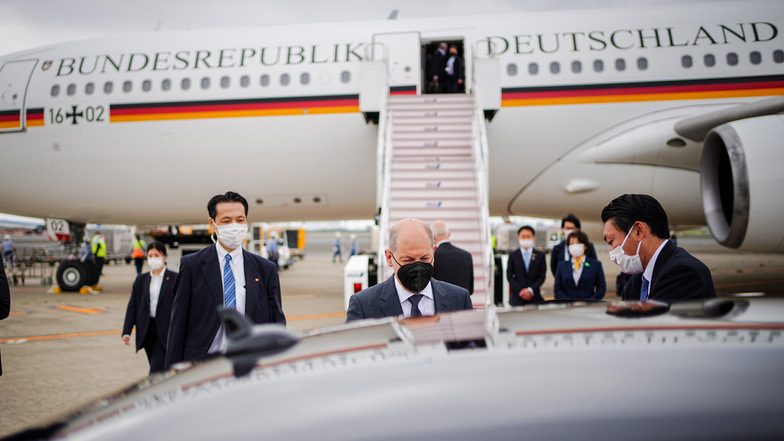 Bundeskanzler Olaf Scholz (SPD) geht nach seiner Ankunft am Airbus A340 der Luftwaffe auf dem Flughafen in Tokio zu der Limousine.