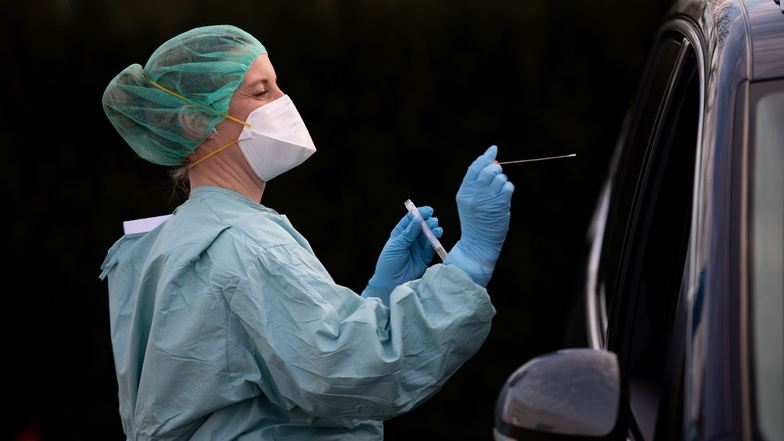 Schleswig-Holstein, Elmshorn: Eine Ärztin entnimmt an einer Drive-in-Teststation einen Abstrich von einem möglicherweise Infizierten. Menschen mit Covid-19 Verdacht können sich hier nach Voranmeldung testen lassen.