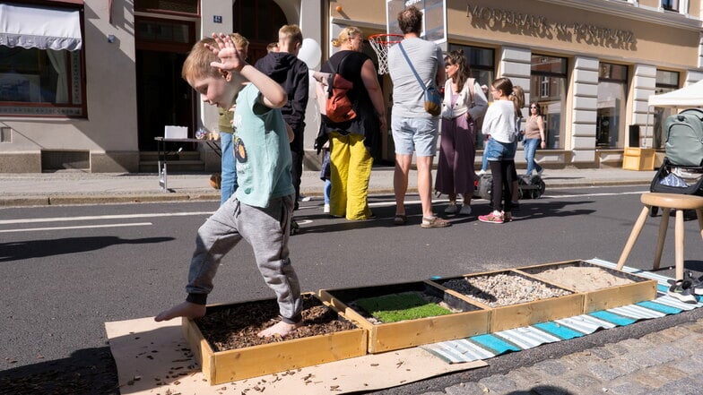 Finn-Luca durchläuft mit seinen sechs Jahren den aufgebauten  Barfußpfad zum Straßenfest in der Jakobstraße.