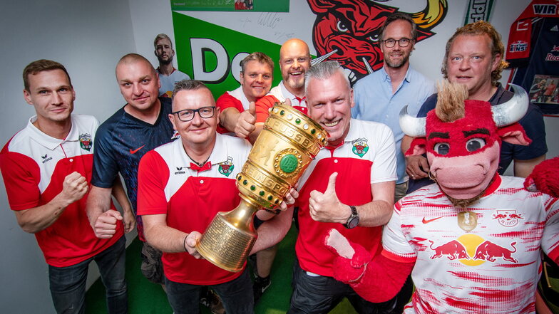 Torsten Hamann (vorn links) und Sören Pauli vom Vorstand des RB-Fanclubs "De Middlsaxn" halten den DFB-Pokal. Zu Gast waren Maskottchen Bulli, Torsten Hahmann (hinten rechts) und Florian Scholz.