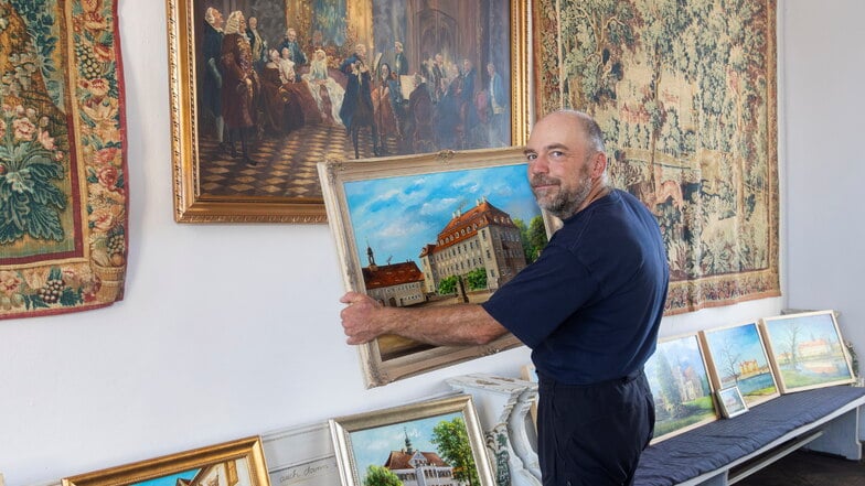 Der Künstler Steffen Gröbner während des Aufbaus zur Vernissage seiner Ausstellung im Schloss Promnitz. In Händen hält er das größte Werk, das er dort zeigt: eine Rekonstruktion des einstigen Schlosses von Grödel.