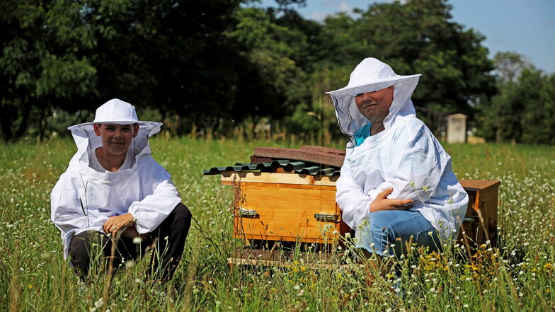 Es summt, es blüht, aber es kann auch mal piksen: Diese beiden Teilnehmer des Sprungbrett-Feriencamps haben sich an den neuen Bienenstöcken auf Gut Göhlis in Schutzkleidung gehüllt.