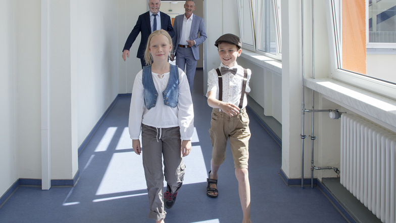 Die Schüler Pauline und Paul führen den Freitaler Oberbürgermeister Uwe Rumberg (hinten links) und den Schulleiter Rene Marth durch das sanierte Schulgebäude.