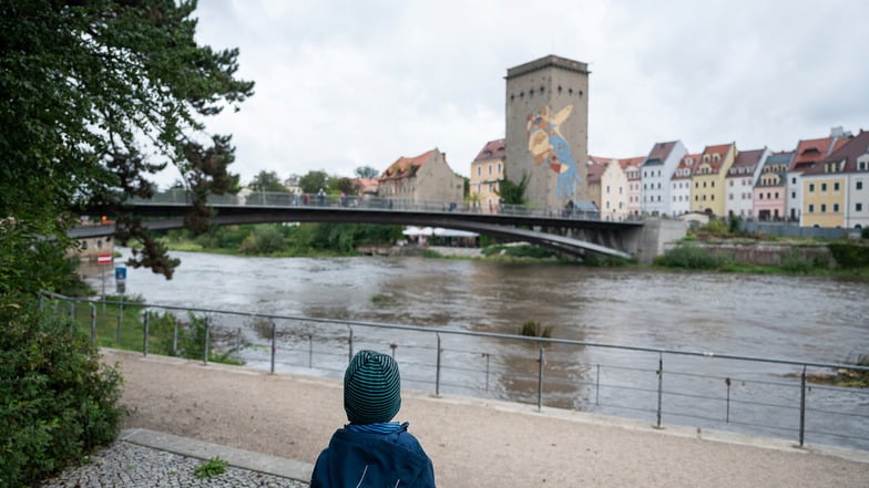 Ein kleiner Junge blickt auf das beginnende Hochwasser der Neiße an der Altstadtbrücke Görlitz.