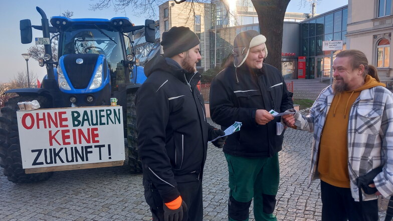 Fritz Gohrisch (l.) und Marcus Schaaf (Mitte) von der Agrargenossenschaft Wülknitz verteilen vorm Riesaer Kino Handzettel an Passanten. René Georgi nimmt einen und hofft, dass die Bauern mit ihrem Protest Erfolg haben.