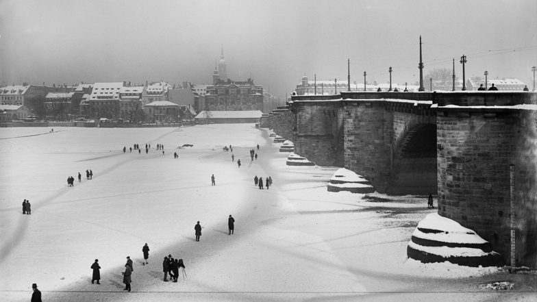 Blick vom Dresdner Altstadtufer unterhalb der Augustusbrücke über die zugefrorene Elbe mit Passanten auf das Neustädter Ufer im Winter 1929.