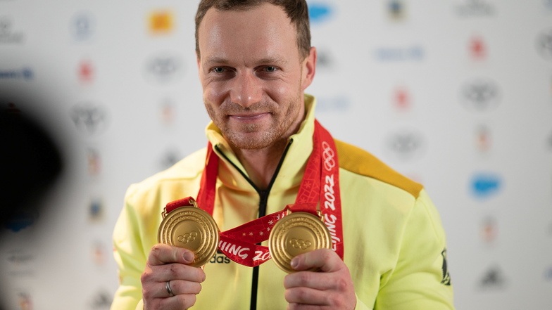 Francesco Friedrich zeigt bei der Rückkehr der deutschen Mannschaft von den Olympischen Spielen in Peking auf dem Frankfurter Flughafen seine Goldmedaillen.