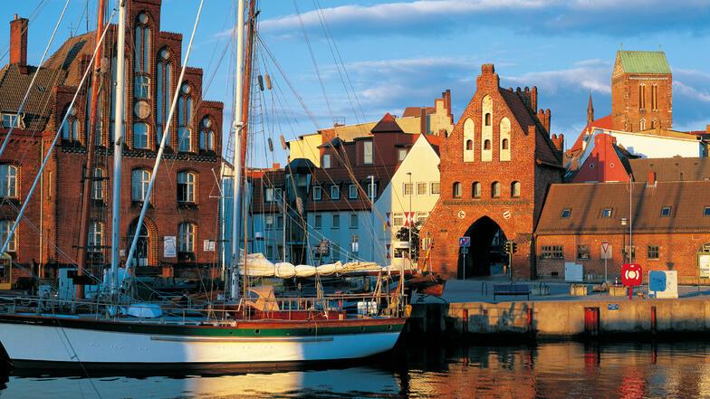 Touristen lassen sich am Alten Hafen den Wind um die Nase blasen – auf der Suche nach Fischbrötchen und einem authentischen Eindruck von Mittelalter und Hanse.