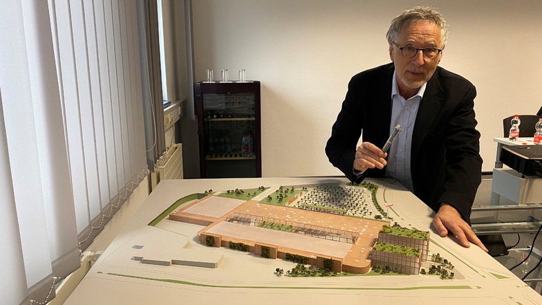 Kurt Krieger zeigt das Modell des neuen Einkaufszentrums, auf dessen Dächern geparkt werden soll.