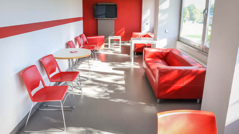 Sofas, Tische und Stühle in Rot-Weiß stehen in den Aufenthaltsräumen auf den Etagen.