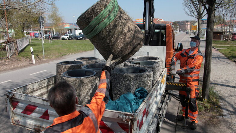 Massiv demontiert: Bauhof-Mitarbeiter sammeln am 28. April 2021 an der Dippoldiswalder Straße in Pirna einen Mülleimer ein.