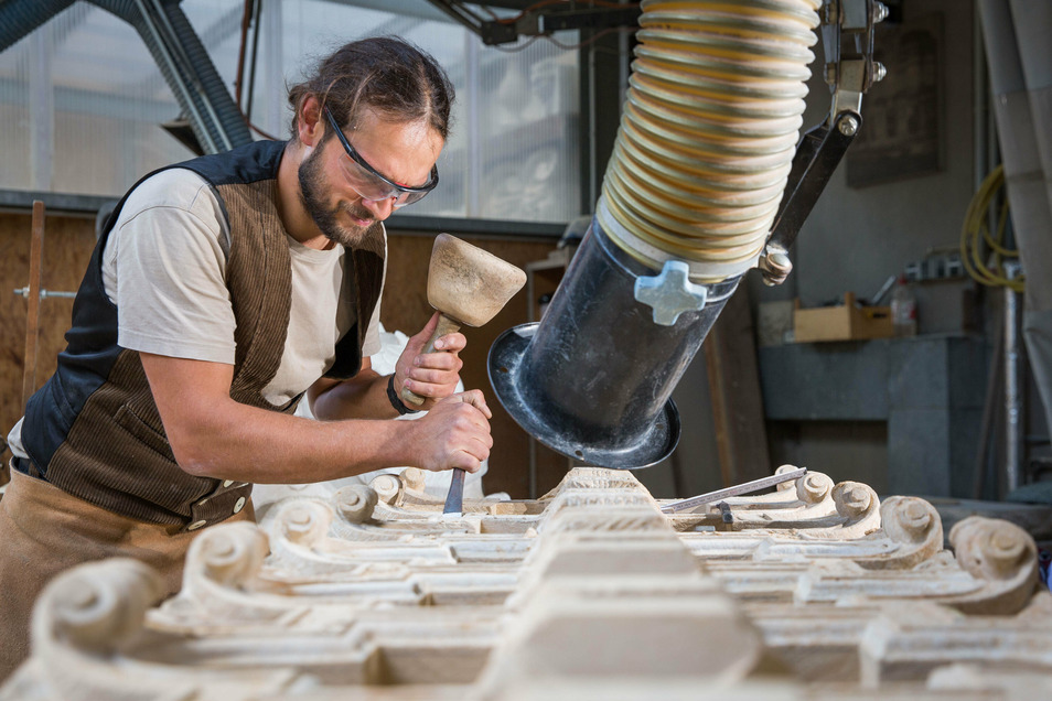 Steinbildhauermeister Clemens Modrakowski arbeitet an einer kunstvoll gestalteten Brüstungsplatte, die nach dem Vorbild des über 300 Jahre alten barocken Originals kopiert wird.