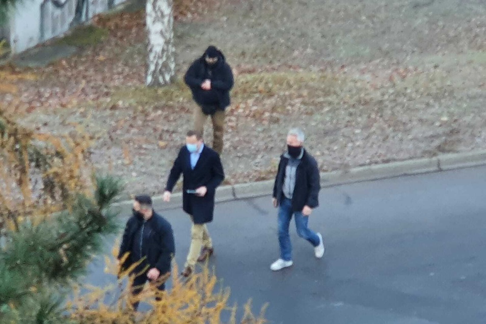 With a tablet in hand and bodyguards around him, Navalny (center) walks around the block.