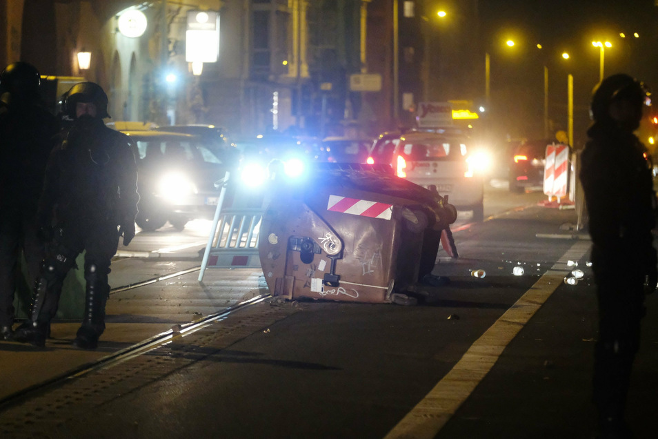 Polizisten stehen auf einer Straße in Leipzig-Connewitz, auf der Gegenstände als Barrikade liegen. Am Rande einer Demonstration kam es dort zu Ausschreitungen.