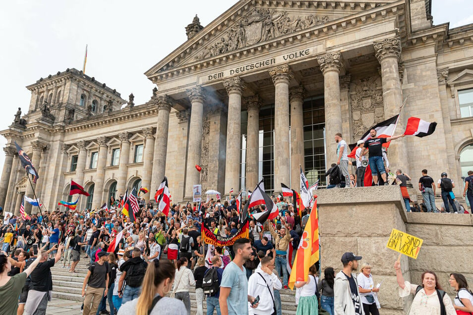 Participants in a rally against the Corona measures are standing on the steps of the Reichstag building at the end of August 2020, numerous Reich flags can be seen.