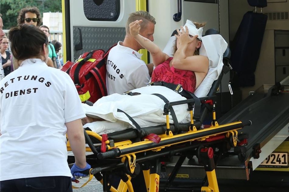 Eine verletzte Gegendemonstrantin wird in einen Rettungswagen geschoben.